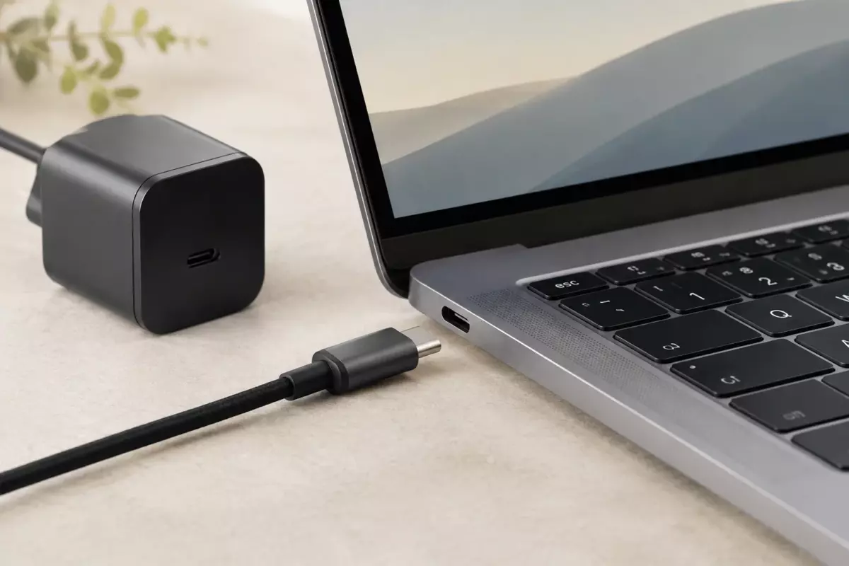 Крупный план разъёма USB-C ноутбука и аккуратного кабеля без маркировок